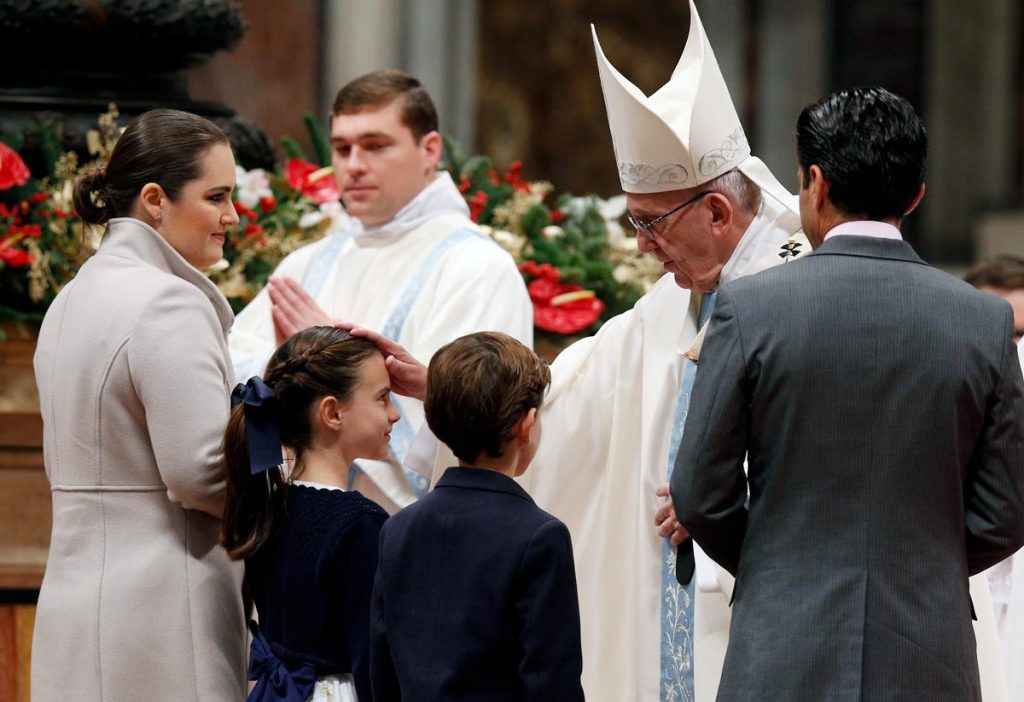 Pope Francis greets a family as they present offertory gifts during a Jan. 1 Mass marking the feast of Mary, Mother of God, and World Day of Peace, in St. Peter's Basilica at the Vatican. In an annual message typically devoted to peacemaking and resolving conflicts on the world stage, the pope included a discussion of family life and marriage. (CNS photo/Paul Haring)