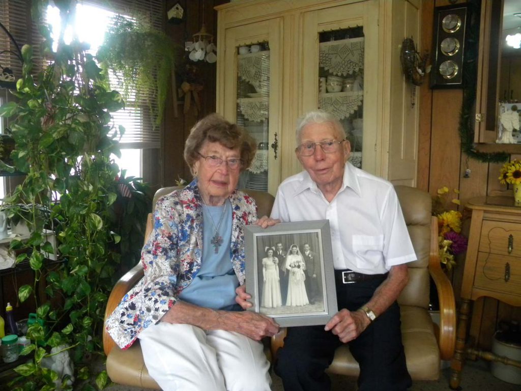 Bill and Evelyn Schulte of Dodge, Neb., seen in a 2016 photo, hold a portrait of themselves taken on their wedding day in 1946. The couple, who are members of St. Wenceslaus Parish in Dodge, will celebrate their 71st wedding anniversary Feb. 12. (CNS photo/Kathy Kauffold, Dodge Criterion)